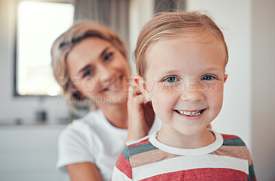 Buy stock photo Loving mother brushing and tying little daughter's hair. Adorable caucasian girl smiling while getting ready. Mom taking care of her daughter 