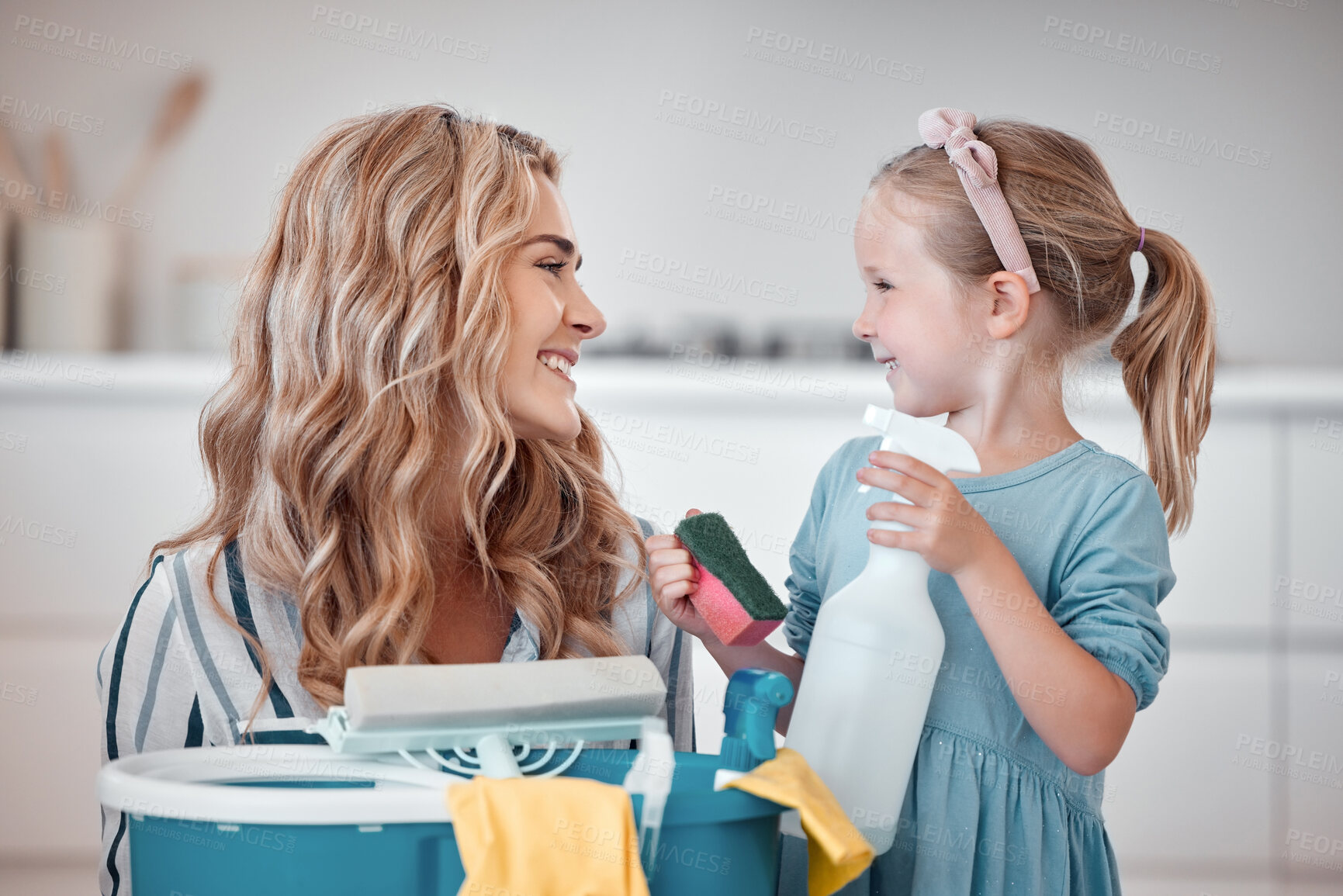 Buy stock photo Little caucasian girl helping her mother with household chores at home. Happy mom and daughter excited to do spring cleaning together. Kid learning to be responsible by doing tasks