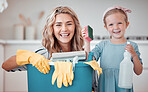 Cute cheerful little girl helping her mother clean at home. Happy caucasian woman smiling while holding cleaning supplies with her daughter at home. Positive mother and child getting ready to clean