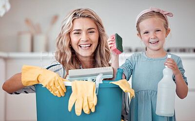 Buy stock photo Cute cheerful little girl helping her mother clean at home. Happy caucasian woman smiling while holding cleaning supplies with her daughter at home. Positive mother and child getting ready to clean