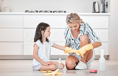 Buy stock photo Mother and daughter wearing gloves, cleaning the floor at home. Cute little girl helping young woman clean the family home. Young child learning about chores and hygiene in their new house
