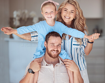 Happy caucasian family relaxing together at home. Carefree loving parents bonding with little daughter. Mom holding her adorable young playful girl sitting on her dad\'s shoulders and pretending to fly