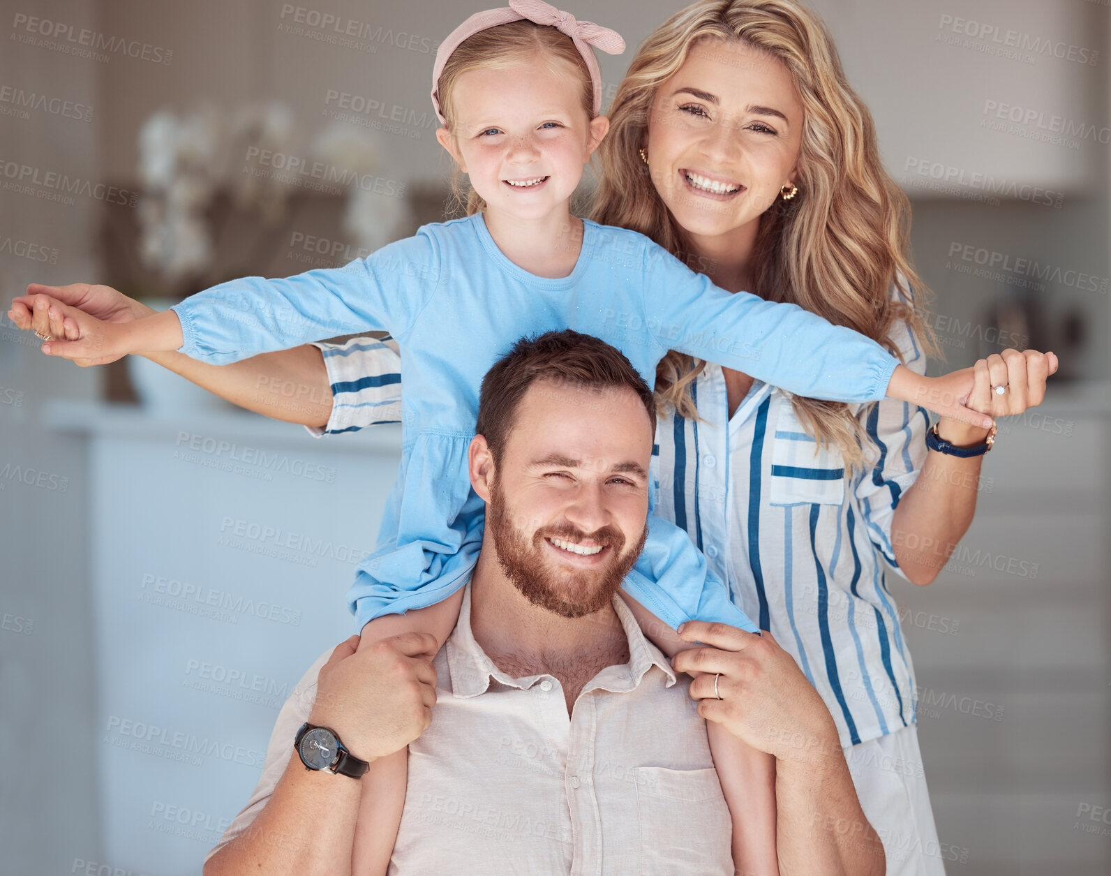 Buy stock photo Happy caucasian family relaxing together at home. Carefree loving parents bonding with little daughter. Mom holding her adorable young playful girl sitting on her dad's shoulders and pretending to fly