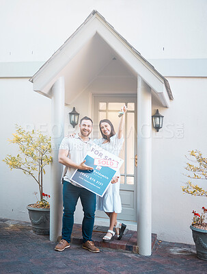 Buy stock photo Couple buying a house together. Couple holding keys in front of their house. Happy couple moving in together. caucasian couple pose outside their new house. Smiling couple outside holding keys