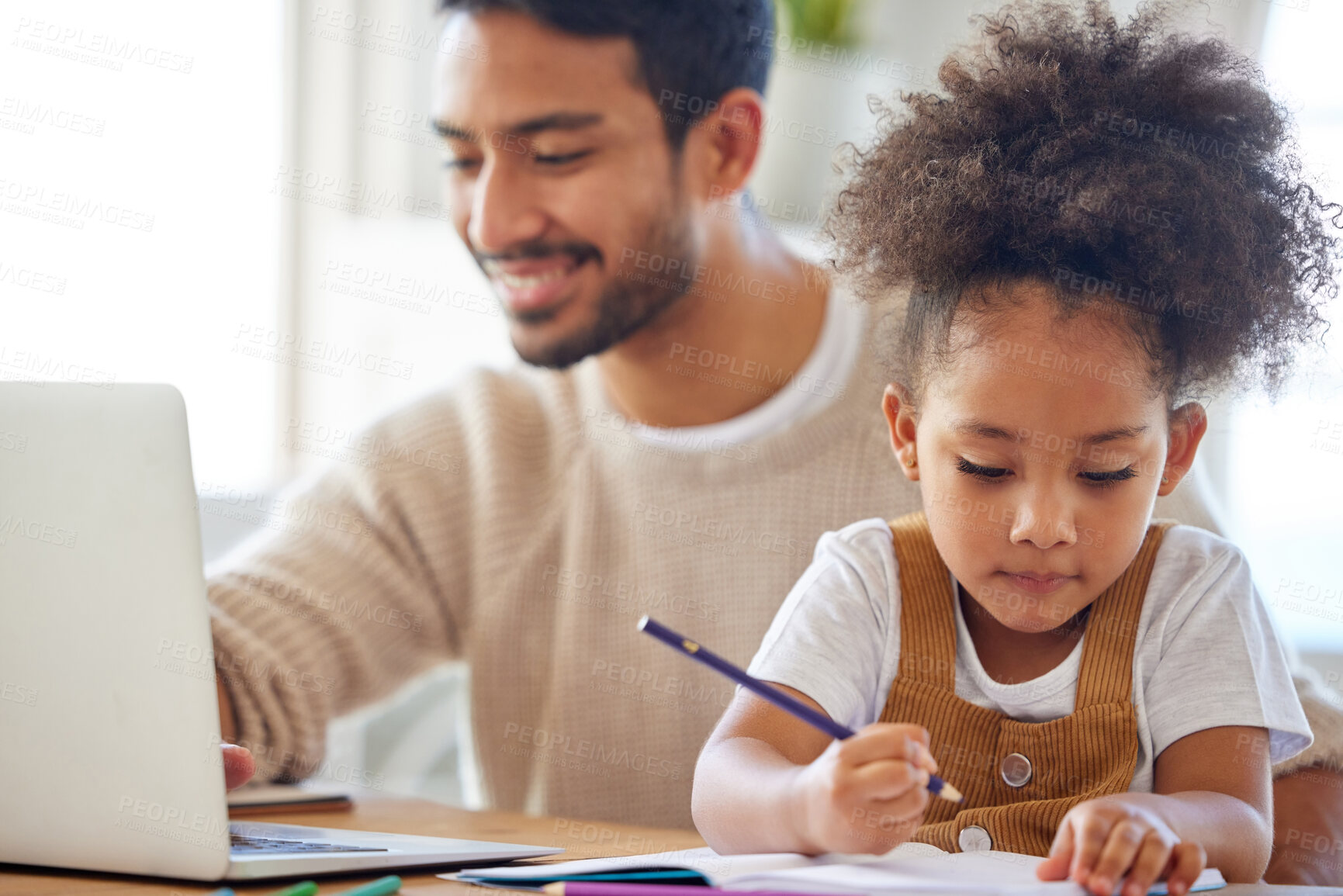 Buy stock photo Young mixed race father working from home on a laptop with his little daughter drawing. Child drawing next to dad who is using a computer. Girl with a curly afro doing homework while her dad works