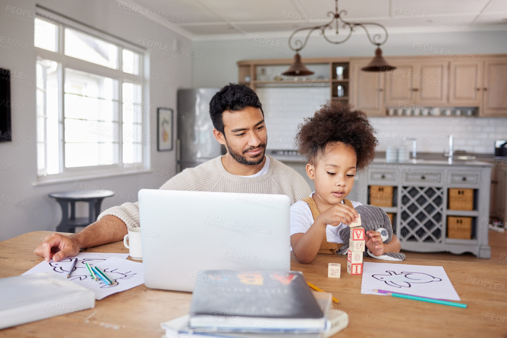 Buy stock photo An adorable mixed race girl with an afro doing her homework in the living room while her young dad works on his laptop. A father and an entrepreneur. Working at home means he's there for his daughter