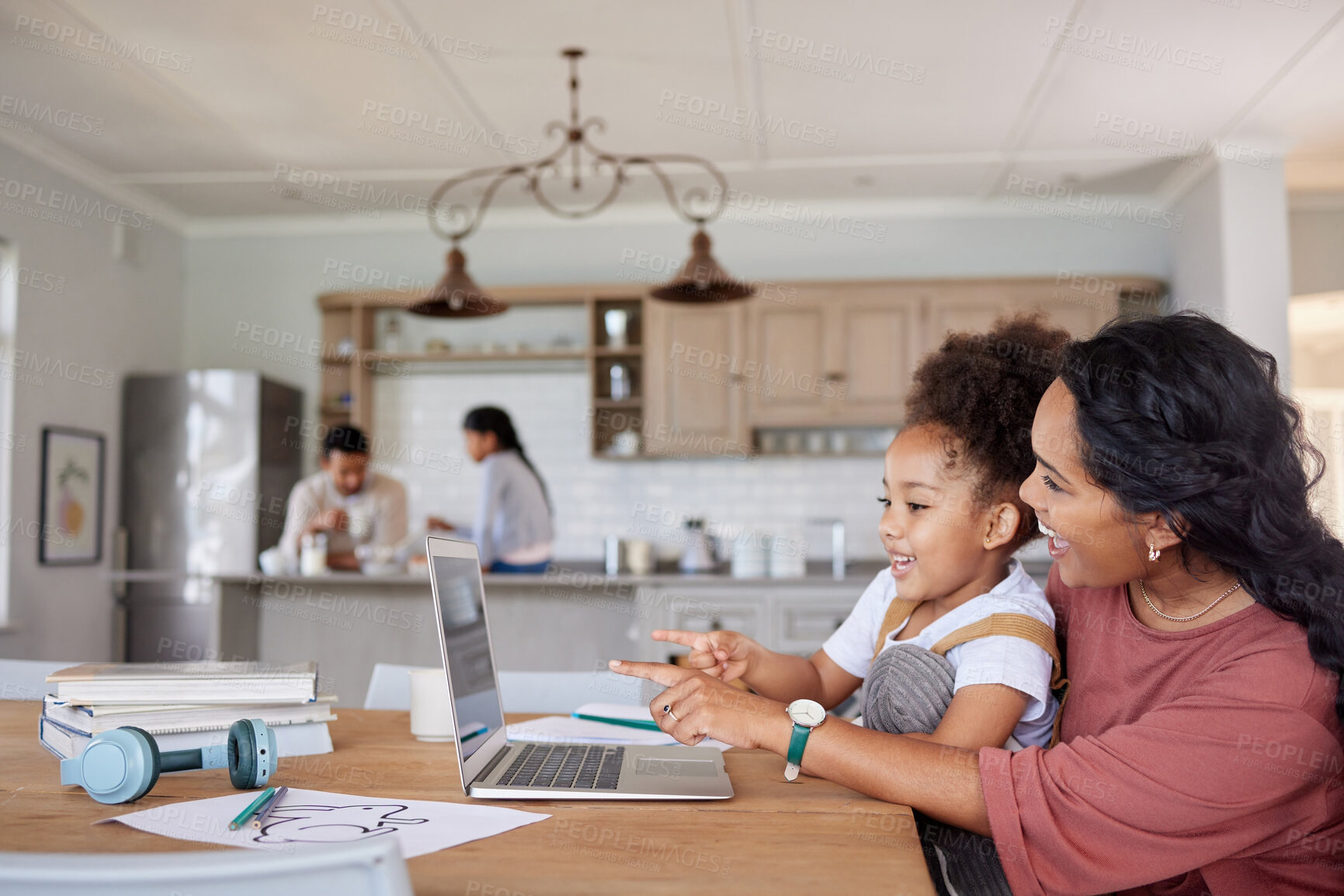 Buy stock photo Mixed race mother and daughter pointing while using a laptop to learn online together in the lounge at home. Little girl pointing her finger while using a laptop with her hispanic mother at home