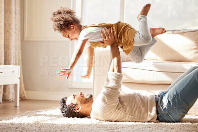 Buy stock photo Father lifting daughter in the air. Excited girl playing with her dad. Young parent playing with their child. Happy dad lying on the floor having fun with daughter. 