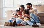 Affectionate and loving mixed race family sitting together. Happy family with two daughters hugging their mother and bonding at home. Two little girls enjoying a happy childhood with mom and dad