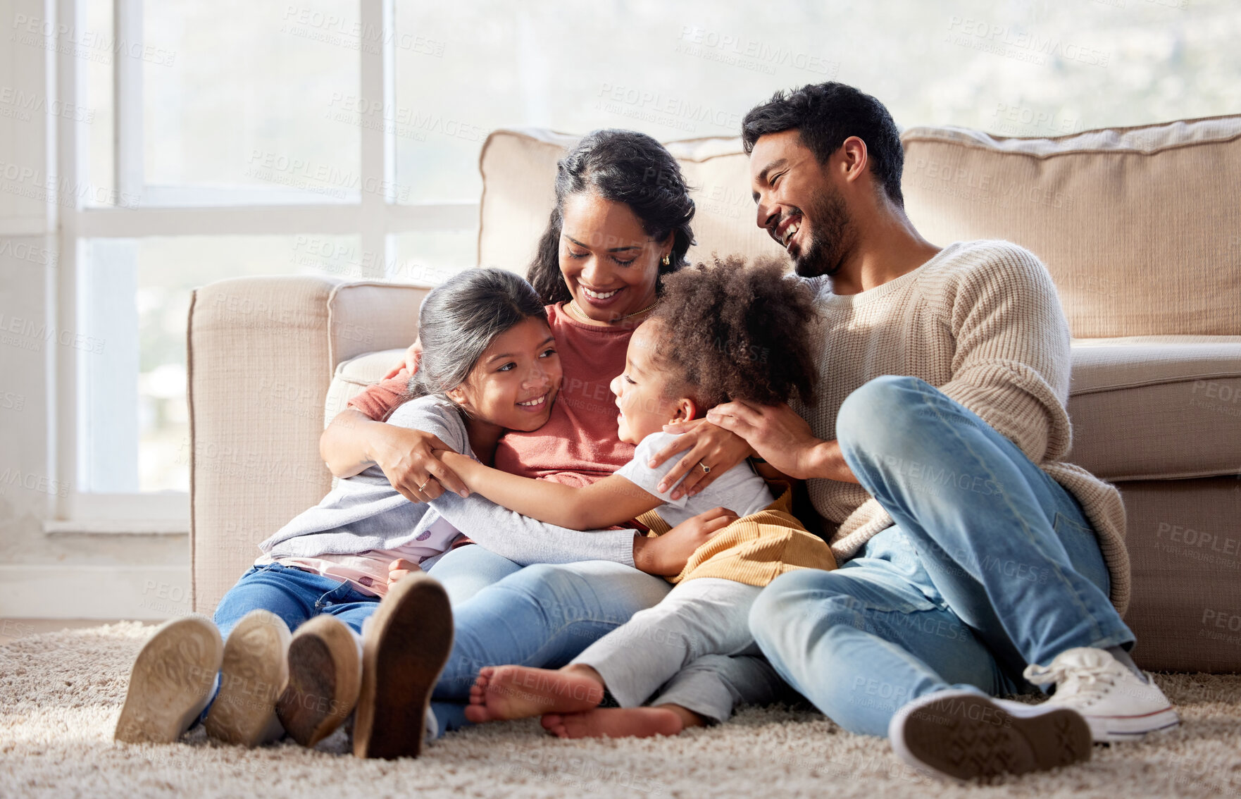 Buy stock photo Love, home and family on the floor, smile and bonding with affection, peaceful and loving together. Parents, mother or father with female children, kids or girl on the ground, lounge or weekend break