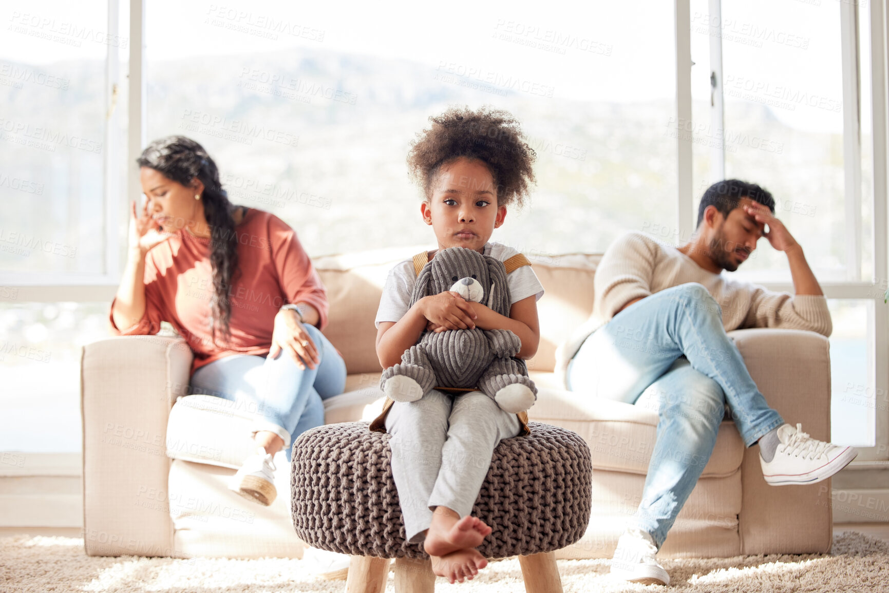 Buy stock photo Scared little kid with afro sitting and holding teddy bear while parents fight. African American couple ignoring each other after arguing in presence of their daughter. Parents divorce affecting child