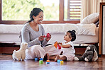 Beautiful young woman and single mother playing toy blocks with her adorable little baby daughter in the bedroom at home. Happy mixed race woman bonding with her little girl. Education starts at home