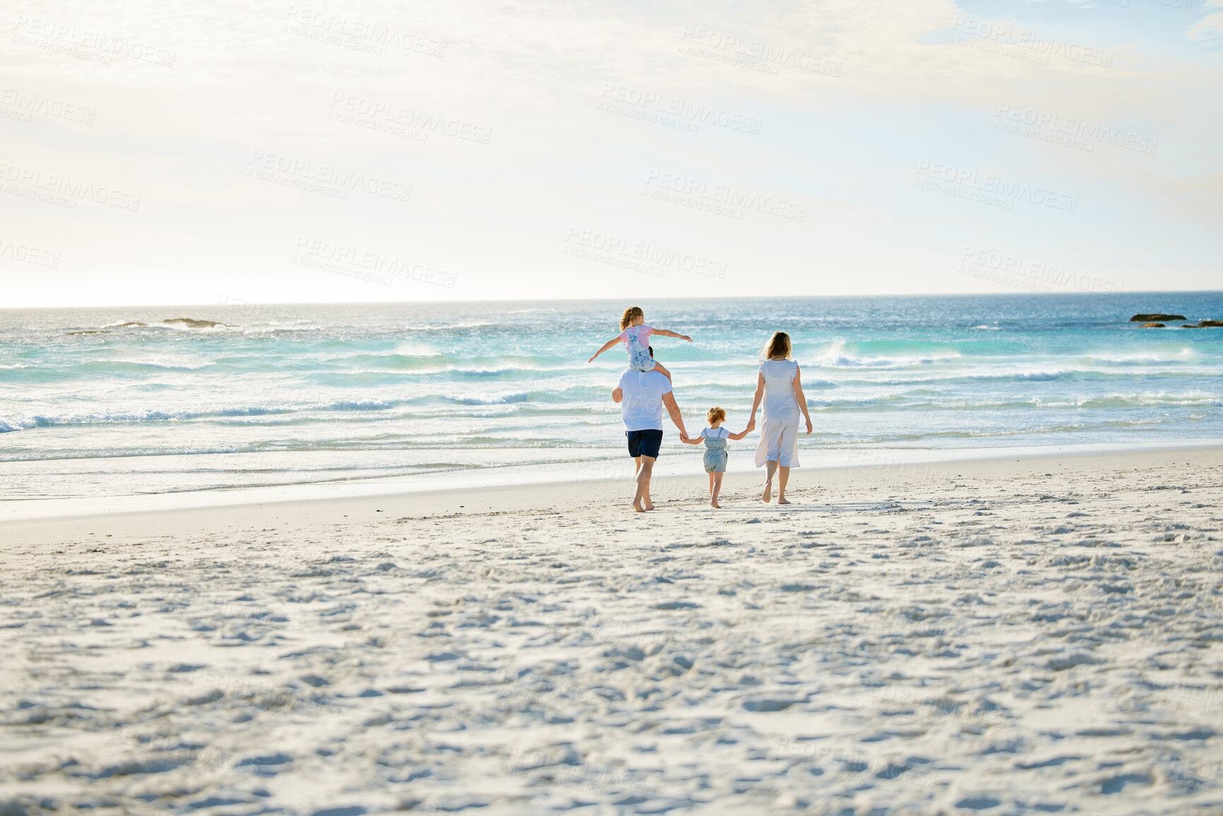 Buy stock photo Happy, holding hands and travel with family at beach for summer, vacation and bonding. Freedom, support and ocean with parents and children walking on seaside holiday for love, care and happiness