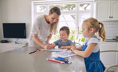 Buy stock photo Young single caucasian mother helping her two cute little children with their homework in a bright kitchen. Two siblings doing their school project with their mom at home 