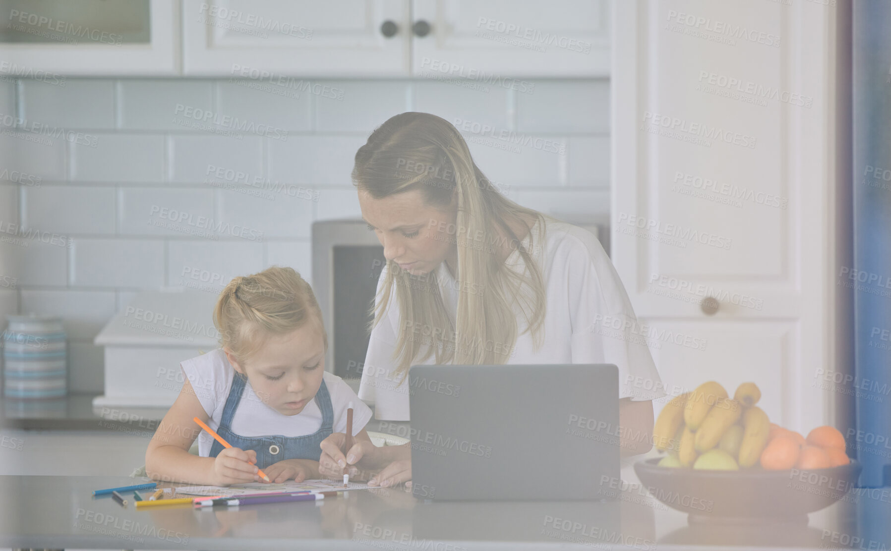 Buy stock photo Mother teaching child to do her homework at home. Relaxed caucasian mother and daughter using a laptop and helping her daughter draw pictures in a modern bright kitchen