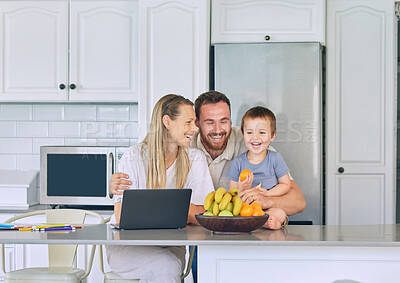 Buy stock photo Happy family relaxing in the kitchen. Little boy eating orange in the kitchen. Cheerful caucasian family at home. Father hugging wife and son. Two parents bonding with their son. Young family laughing