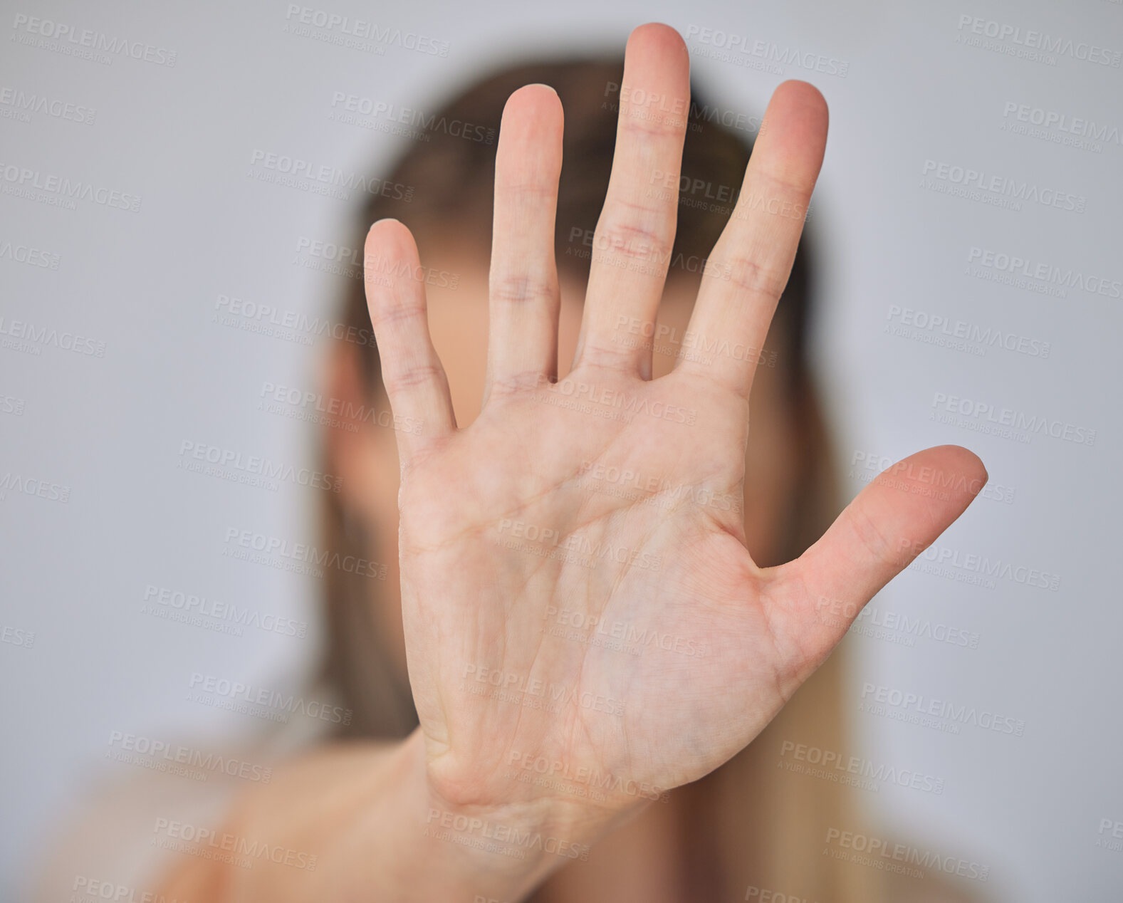 Buy stock photo Closeup of of the hand of a caucasian business woman gesturing stop while standing against a grey background. Stop gender based violence, sexual harassment and bullying. Take a stand. Enough is enough