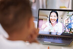 Little girl on a video call with her teacher using a laptop. Young female teacher doing a virtual lesson using blocks with her student. Little girl doing a virtual speech therapy session with a woman