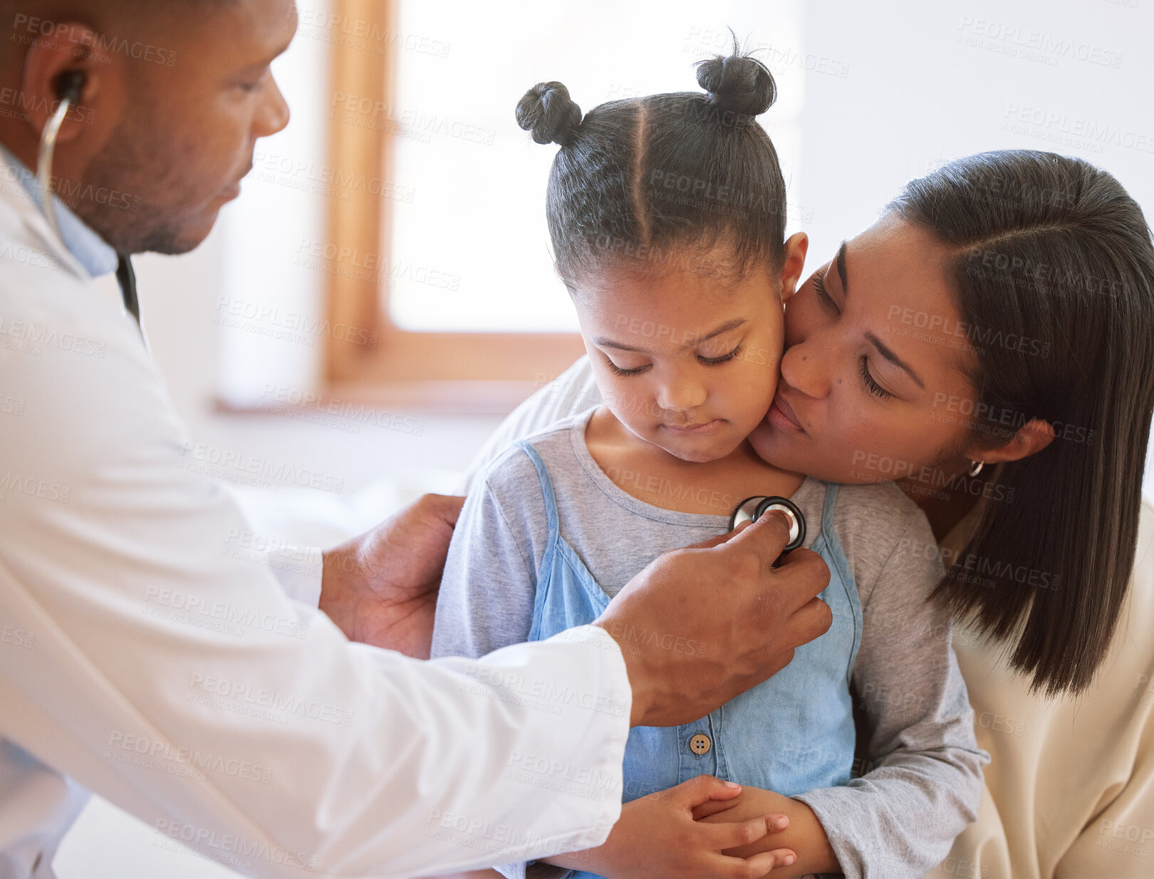 Buy stock photo Sad little girl at doctor's office. Sick girl sitting with mother while male paediatrician listen to chest heartbeat. Male doctor examining child with stethoscope. Mom holding kid during doctor visit 