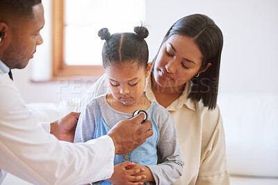 Sick child at doctor\'s office with her mother. Little girl sitting with mother while male paediatrician listen to chest heartbeat. Male doctor examining child with stethoscope. Mom holding kid during doctor visit