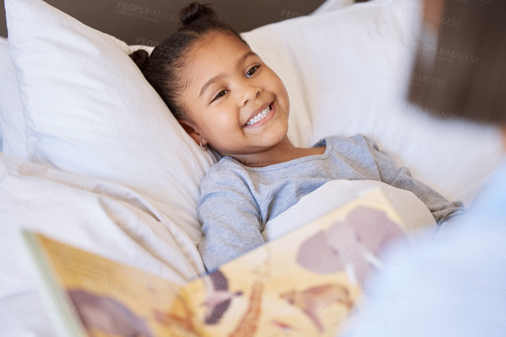 Buy stock photo Mother reading story book to daughter at bedtime. Adorable little girl lying comfortable in bed and enjoying a story while being tucked in by mom. Learning about animals 