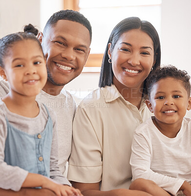 Buy stock photo Portrait of smiling mixed race family relaxing together at home. Carefree loving parents bonding with cute little son and daughter. Happy kids spending quality time with mom and dad