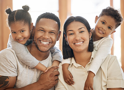 Buy stock photo Portrait of smiling mixed race family relaxing together at home. Carefree little son and daughter hugging their loving parents. Happy kids bonding and spending quality time with mom and dad