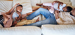 Relaxed african american family smiling while lying on the couch. Above shot of a young happy black couple relaxing while talking to their young adorable son and daughter on a sofa at home