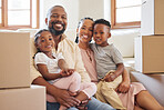 Happy african american family smiling while sitting on the floor in a new home. Portrait of a young happy black couple with two children moving boxes into their new house. Black couple buying property