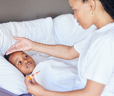 African american woman taking temperature of her son. Mother using thermometer to measure son\'s temperature. Sick little boy lying in bed. Worried mother feeling sons fever.