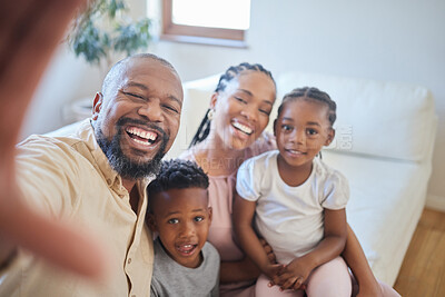 Buy stock photo Portrait of a young african american family sitting on the sofa together and smiling while taking a selfie at home