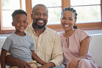 Buy stock photo Portrait of a young african american family sitting on the sofa together and smiling at home