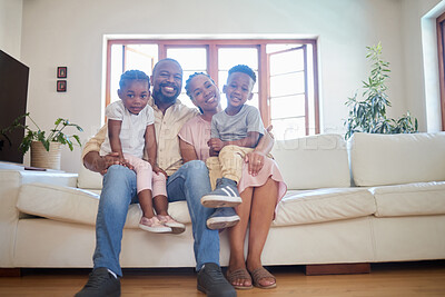 Buy stock photo Portrait of a young african american family sitting on the sofa together and smiling at home