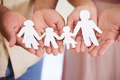 Closeup of a couples hands holding paper cutout of a perfect family. Symbol of home cover, insurance, health, adoption, custody, law, safety, security protection, foster, adoption family home concept