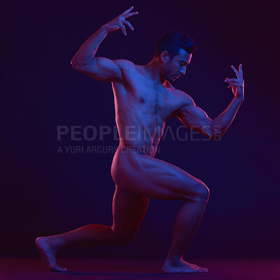 Seductive naked man posing in a studio. Muscular model flexing his biceps. Strong, nude man posing on a dark background. Alluring man posing in a studio. Nude male model on a dark background