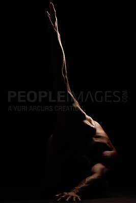 An unknown muscular man showing his athletic shape while posing against a dark copyspace background . Strong fit male flexing his muscles shadow and dark concept