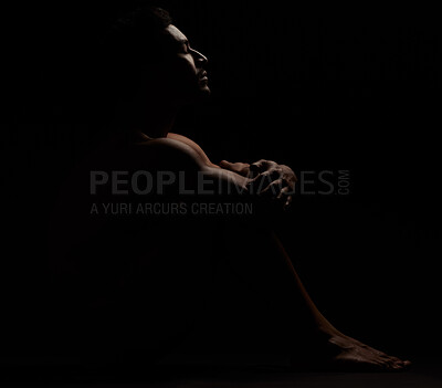 Asian man posing nude and sitting while isolated against a dark studio background. Strong and muscular athlete showing naked body in creative, artistic studio. Sexy hot model feeling sensual and free