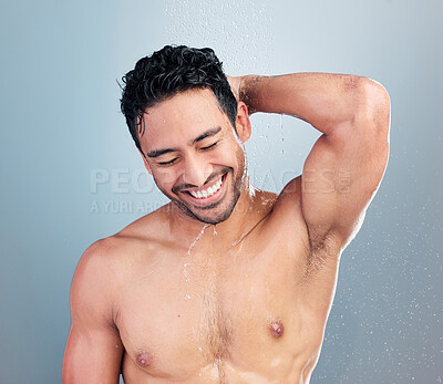 Buy stock photo One muscular young mixed race man feeling fresh during a hot shower against a blue studio copyspace background. Hispanic guy smiling washing hair and body under clean running water for good hygiene 