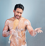 Handsome young man singing in the shower. Happy mixed race male holding shower brush while rinsing soap off his body under clean running water. Handsome hunk doing his morning self-hygiene and body care routine