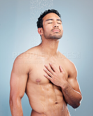 Buy stock photo Sensual man taking refreshing shower. Clean water running down a muscular mixed race man's sexy toned chest with six pack abs. During shower for daily hygiene and bodycare against studio background