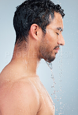 Buy stock photo Young mixed race man standing in the shower with water running down his body during his morning grooming routine. Serious hispanic guy rinsing his body with a warm shower practicing good hygiene