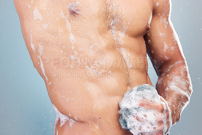 Buy stock photo Closeup of man in the shower. Man rubbing soap on his stomach. Naked man washing his body with a loofah. Muscular man cleaning his body. Male model showering in studio. Man hygiene bodycare routine.