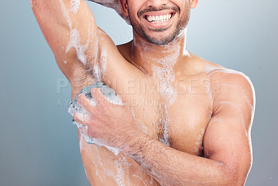 Buy stock photo One happy muscular young mixed race man taking a warm shower against a blue studio background. Hispanic guy washing his body with soap under clean running water for good hygiene