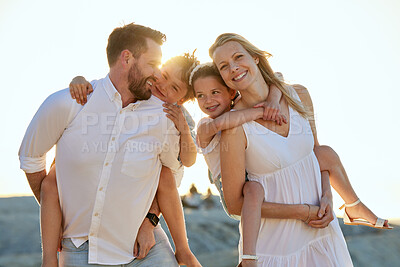 Buy stock photo Family at the beach. Portrait of a happy caucasian couple carrying their kids on their backs at the beach. Smiling mother and father piggybacking their son and daughter on a sunny summer day