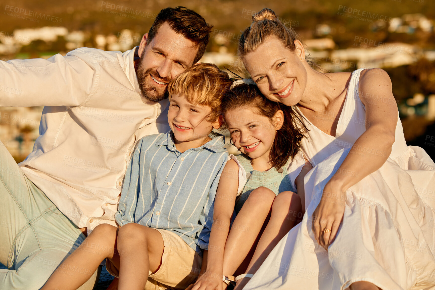Buy stock photo Carefree caucasian family watching the sunset together on the beach. Loving parents spending time with their son and daughter on holiday. Little siblings bonding with mom and dad on vacation
