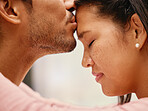 Closeup of mixed race man kissing his girlfriend's forehead. Headshot of hispanic couple bonding and sharing an intimate moment at home. Beautiful woman with freckles feeling in love with boyfriend