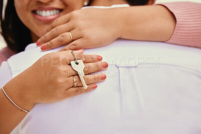 Buy stock photo Closeup woman hugging husband while holding house keys. Loving mixed race couple celebrating after buying new of first home together. Woman receiving key to apartment. Couple moving in together 