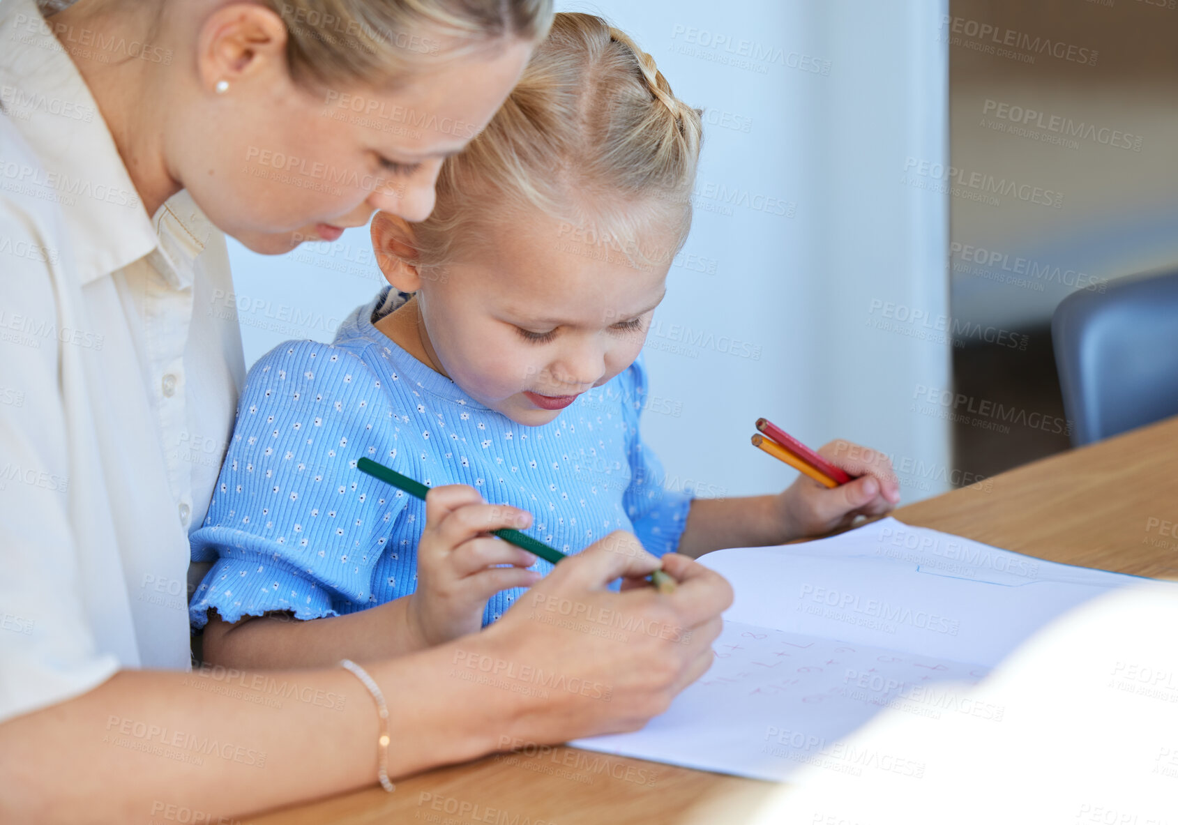Buy stock photo Mother teaching little daughter during homeschool class at home. Cute little caucasian girl learning how to read and write while her parent helps her. Woman showing and talking while tutoring a child