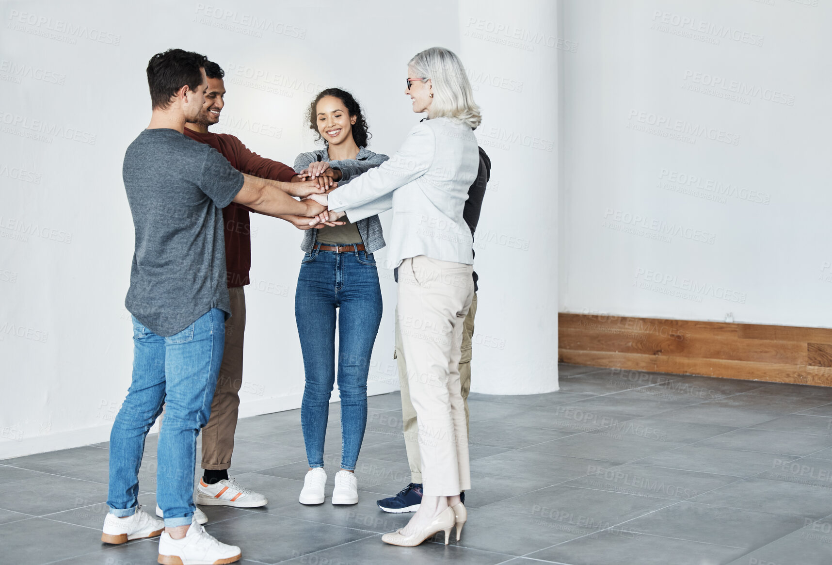 Buy stock photo Diverse businesspeople huddled with hands stacked. Group of businesspeople motivating each other. Team of businesspeople in a circle hands stacked. Businesspeople celebrating their success together