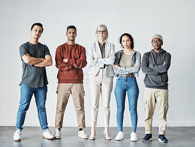 Portrait of team of focused united young business people folding arms. Diverse mixed race group of men and women standing in row in office, looking serious, powerful against grey background copyspace